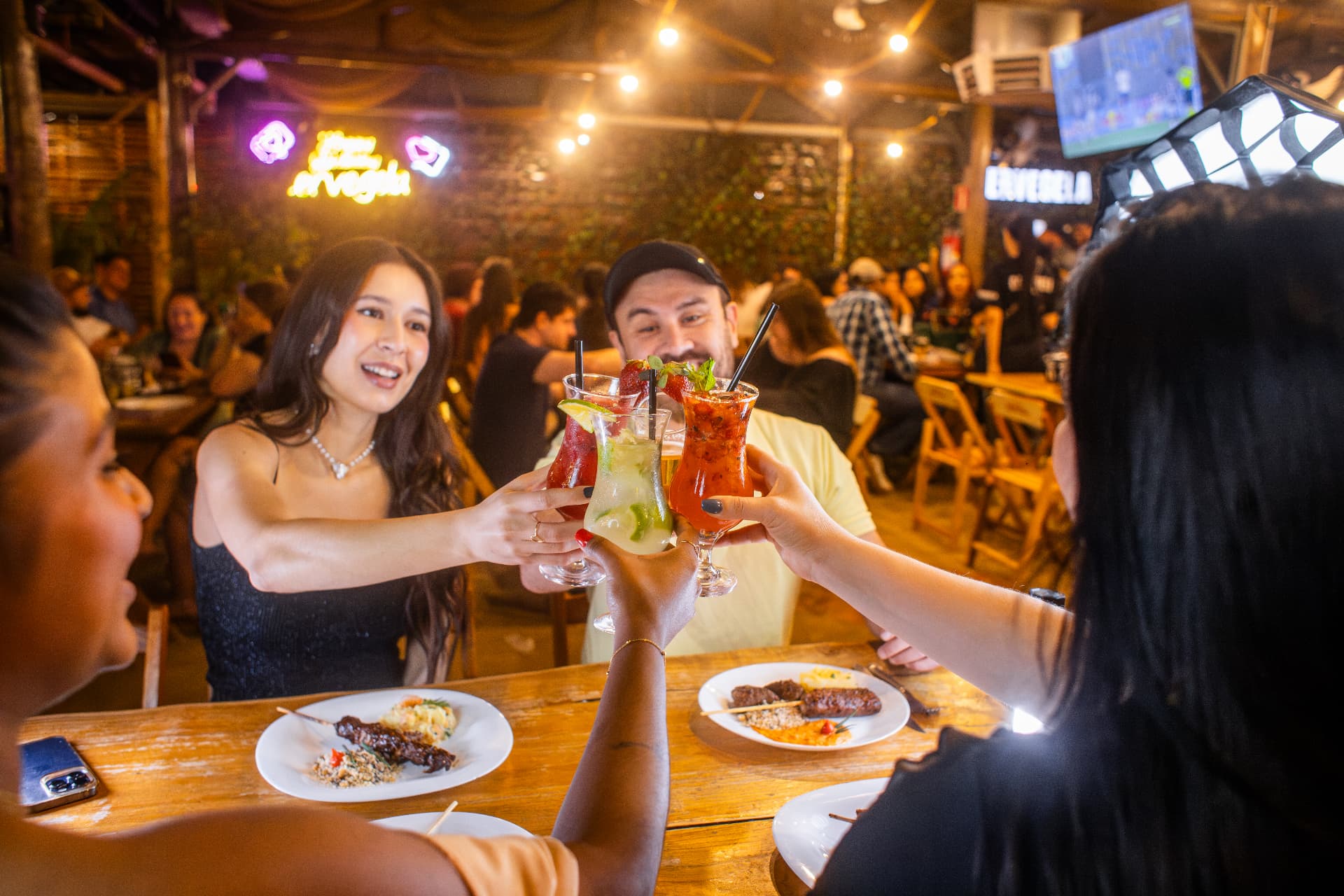 Amigos brindando com drinks no salão da Espetaria Cervegela